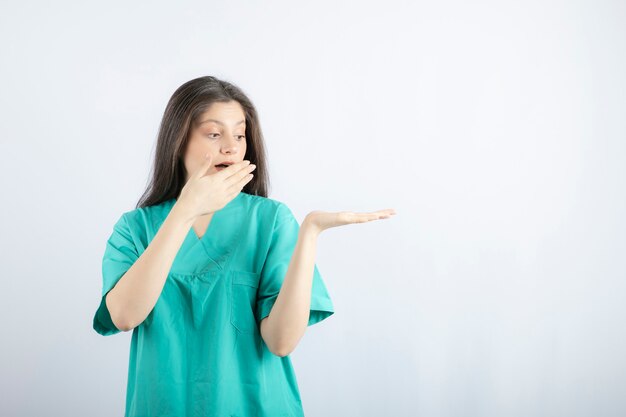 Shocked medical worker holding her hand up .