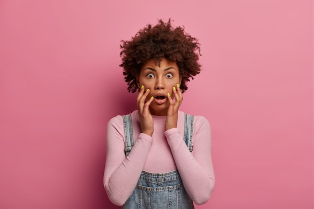 Free photo shocked panic afro american woman excited by unexpected news, grabs face