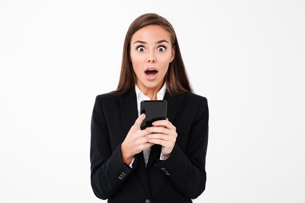 Shocked pretty businesswoman chatting by phone