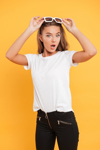 Shocked pretty young woman standing isolated