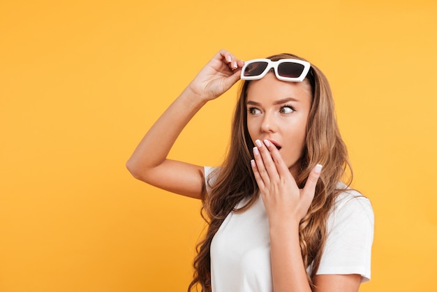 Shocked pretty young woman standing isolated