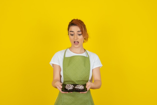 Shocked redhead holding fresh cookies