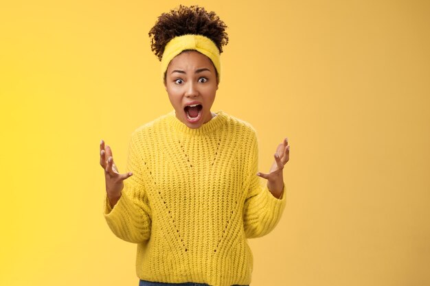 Shocked stunned african-american disappointed woman cannot believe friend messed up project look frustrated annoyed upset complaining arguing raise hands dismay questioned stare camera.