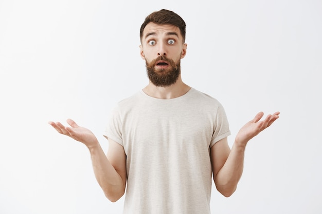 Free photo shocked and surprised bearded guy looking astonished