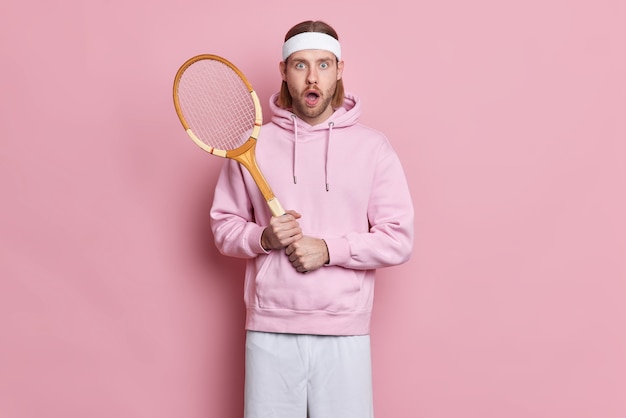 충격을받은 테니스 선수가 라켓을 입고 머리띠 스웨트 셔츠를 입고 경쟁을 잃고 활동적인 라이프 스타일을 이끈다.