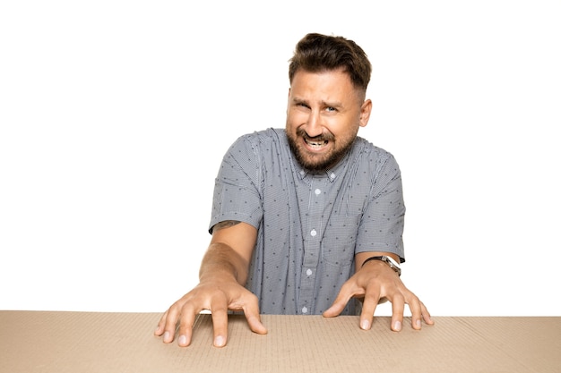 Free photo shocked and upset man opening the biggest postal package.