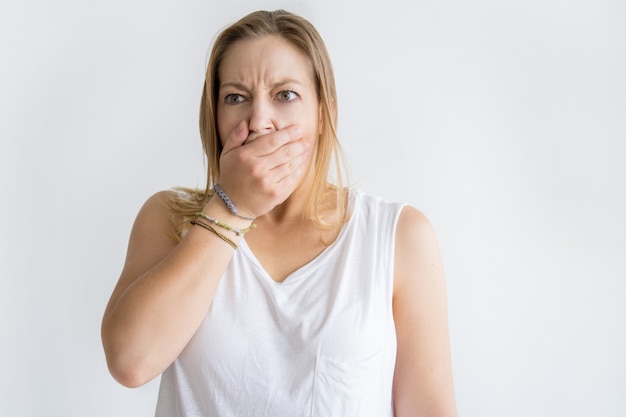 Foto gratuita bocca della copertura della donna colpita con la mano