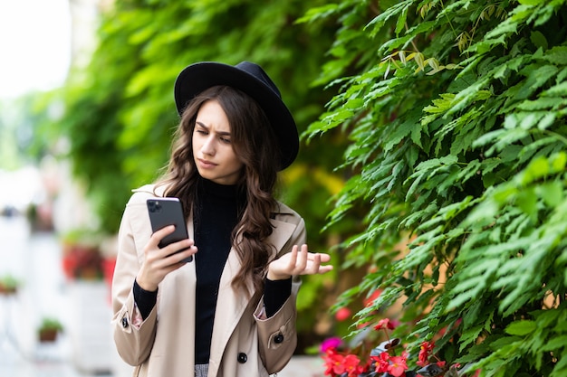 Шокированная женщина находит удивительные новости на смартфоне на улице