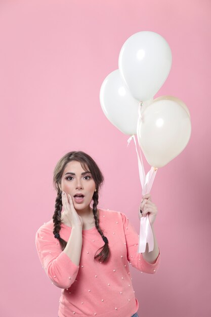 Shocked woman holding balloons