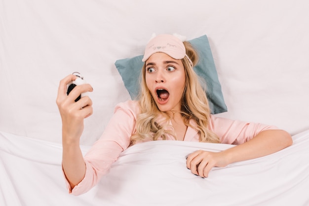 Shocked woman looking at clock