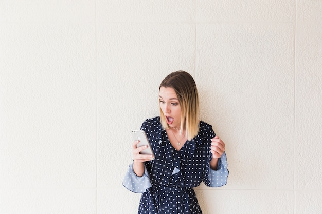 Shocked woman looking at mobile phone