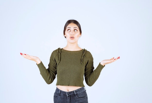 A shocked woman model looking up and showing her empty hands.