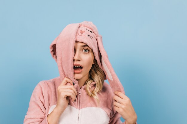 Shocked woman posing in pink bunny suit