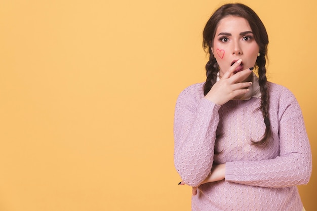 Free photo shocked woman posing while covering her mouth