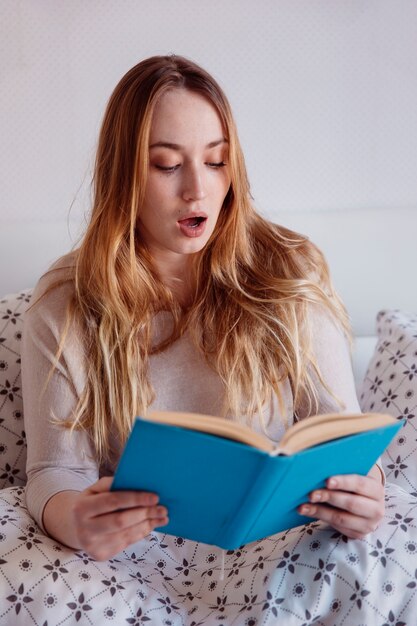 Shocked woman reading book