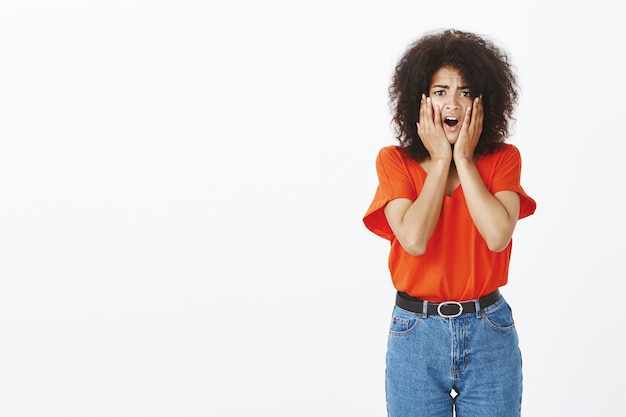 Shocked woman with afro hairstyle posing in the studio