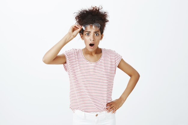 shocked woman with afro hairstyle posing in the studio