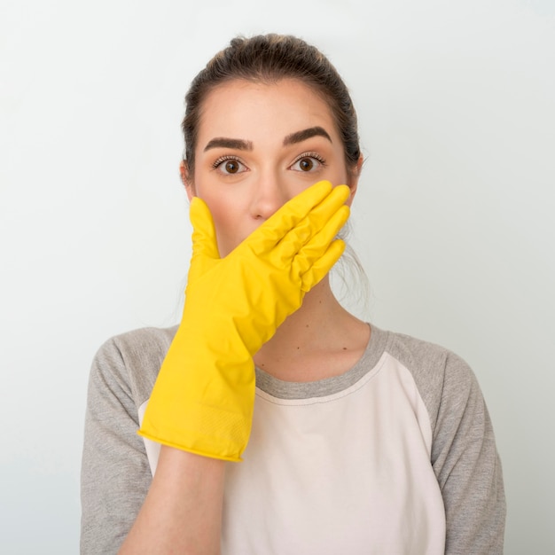 Free photo shocked woman with cleaning glove on hand