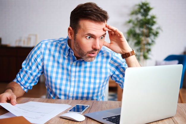 Free photo shocked and worried man working in his office