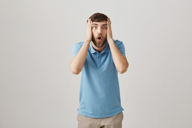 Shocked worried young bearded man posing