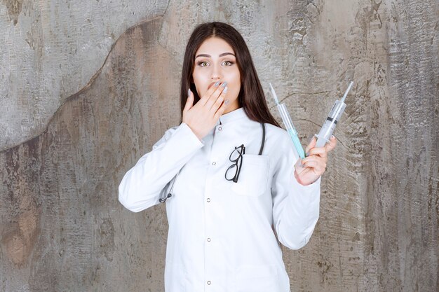 An shocked young doctor Holding injections with hand