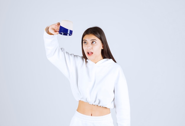 shocked young girl looking at an empty cup.