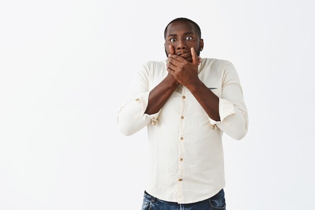 Shocked young guy posing against the white wall