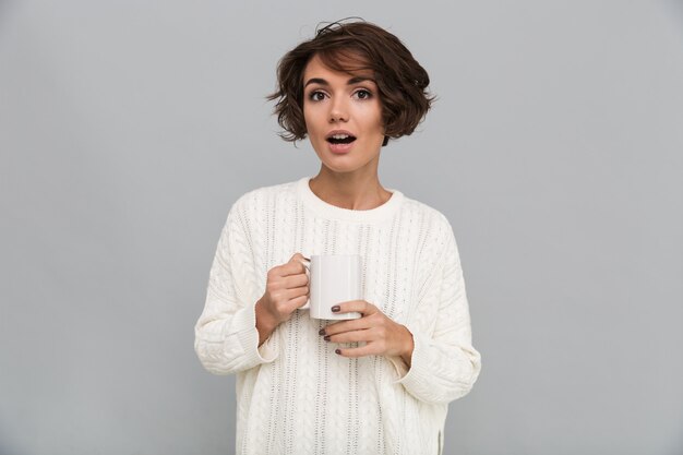 Shocked young lady drinking tea.