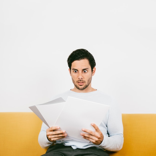 Shocked young man checking the papers