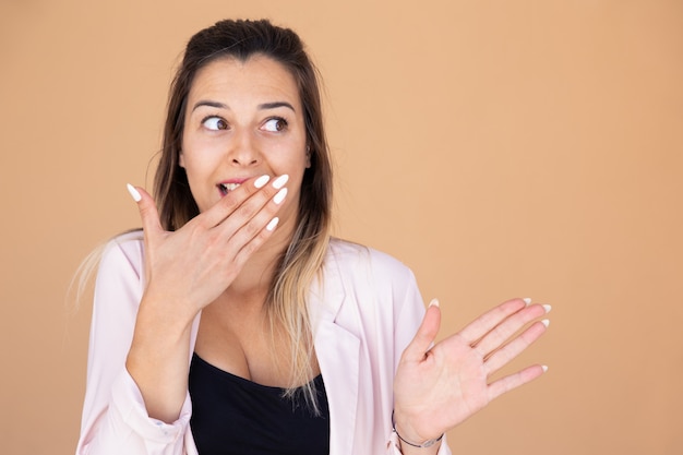Free photo shocked young woman covering mouth with hand