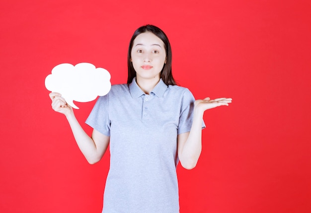 Free photo shocked young woman holding board and don't know what to do