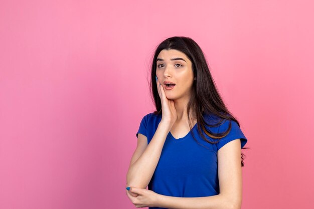 Shocked young woman holding her hand to her face and looking aside with open mouth High quality photo