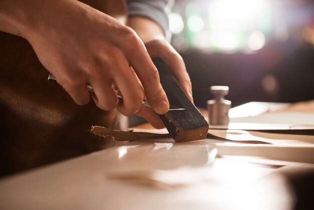 Shoemaker sharpening a knife