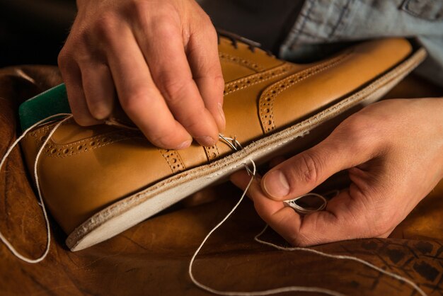 Shoemaker in workshop making shoes