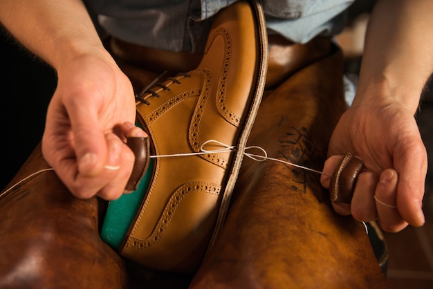 Shoemaker in workshop making shoes