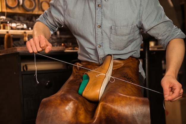 Free photo shoemaker in workshop making shoes