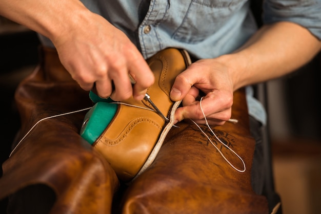 Foto gratuita calzolaio in officina che produce scarpe