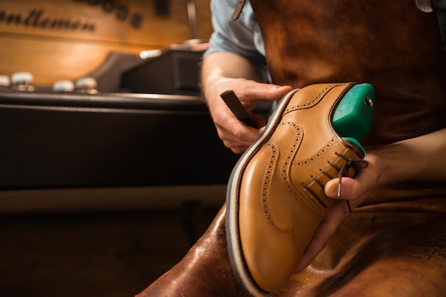 Shoemaker in workshop making shoes