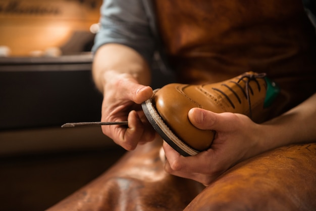 Shoemaker in workshop making shoes