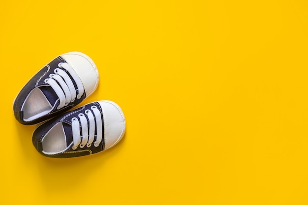 Premium Photo | Shoes for newborns on a yellow.