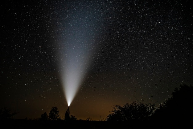 Free photo shooting stars seen near a flashlight held by man