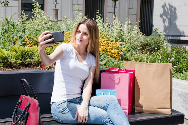 Donna di Shopaholic che prende selfie sullo smartphone
