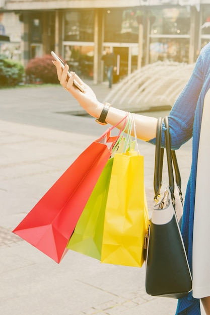 Shopper with bags and smartphone