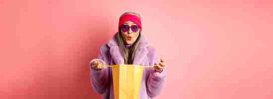 무료 사진 쇼핑 및 패션 개념 선글라스와 가짜 모피 코트 오픈 종이에 세련 된 아시아 노인 여성