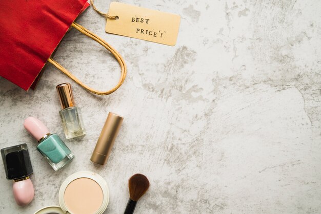 Shopping bag with little tag near lipstick and nail polish