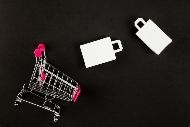 Shopping cart and bags on black background