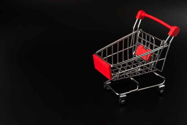 Shopping cart on dark background with copy-space