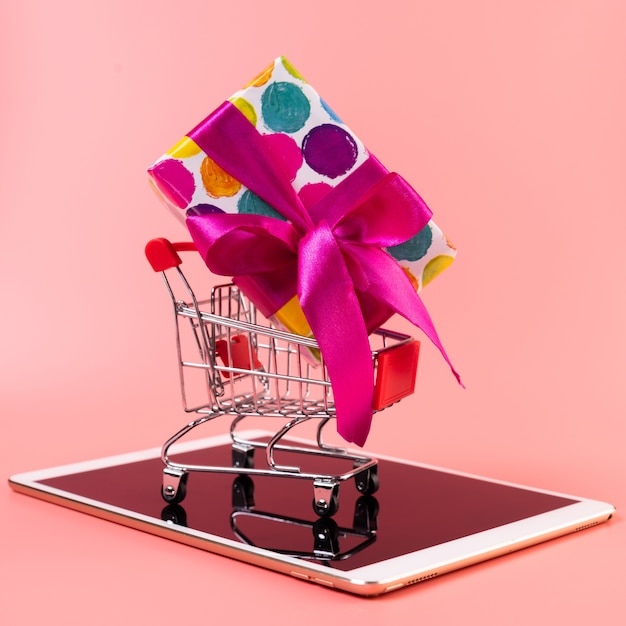 Shopping cart with gift on top of tablet