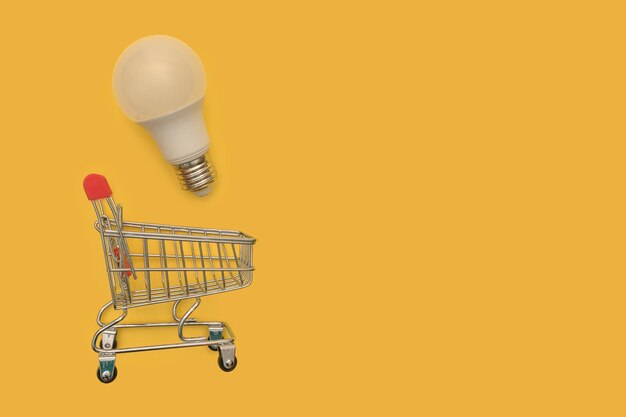 Shopping cart with a light bulb. mini cart. online purchase of light bulbs.