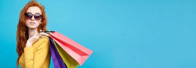 Shopping concept close up portrait young beautiful attractive redhair girl smiling looking at camera